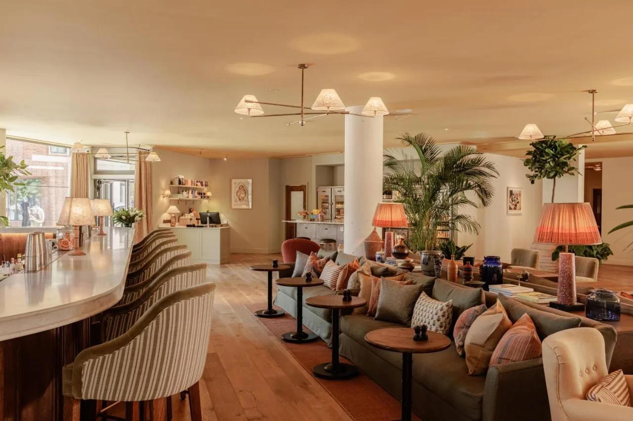 a living room with couches and a bar at Wilde Cambridge City Centre in Cambridge