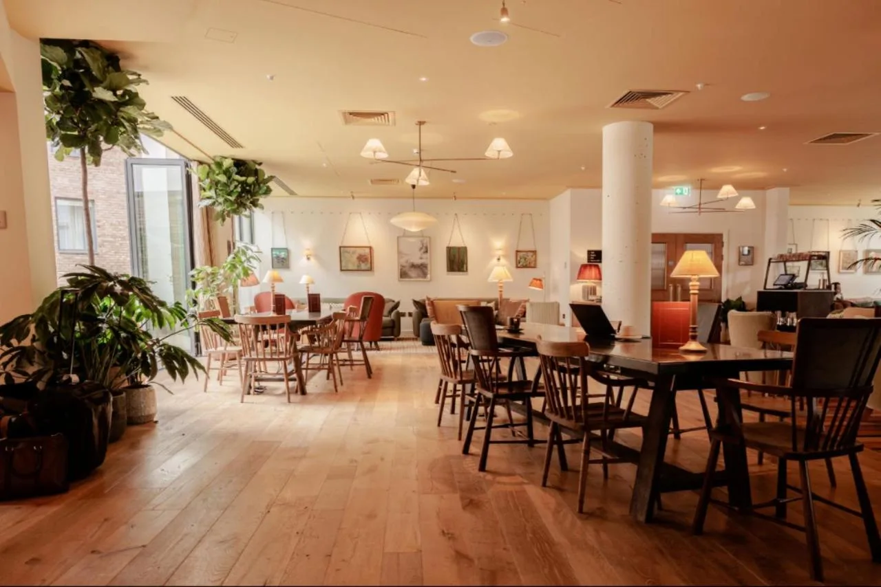 a dining room with tables and chairs in a building at Wilde Cambridge City Centre in Cambridge